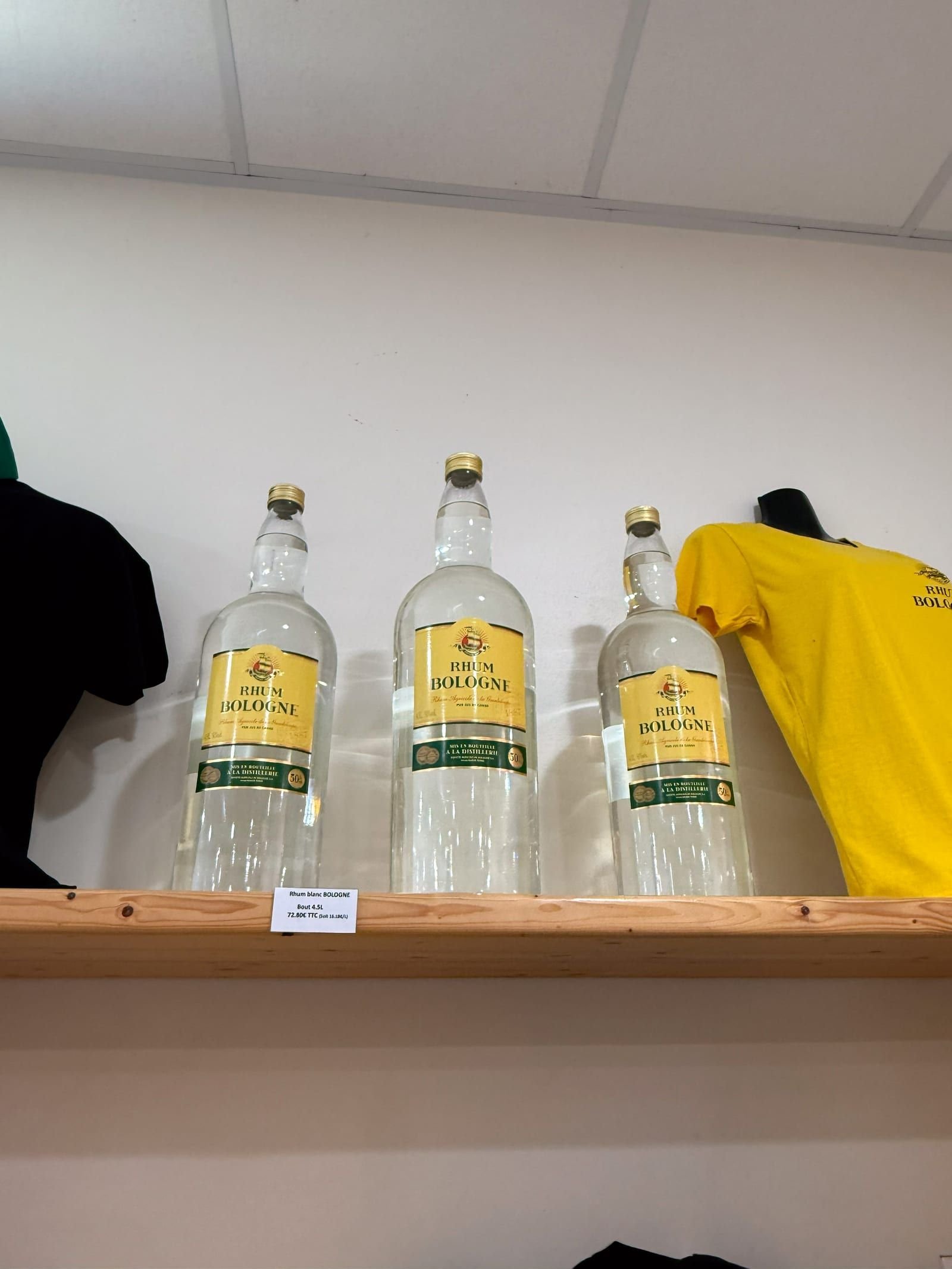 Trois bouteilles de rhum blanc Bologne en grand format, alignées sur une étagère claire.